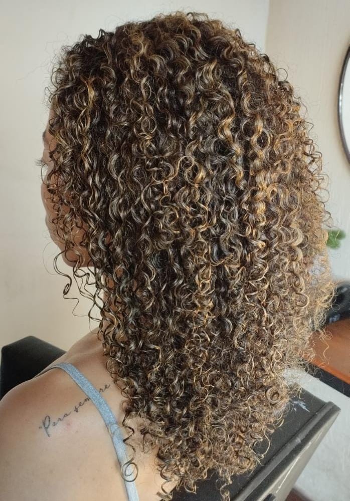 Morena iluminada cacheada com pó descolorante. Morena iluminada mel